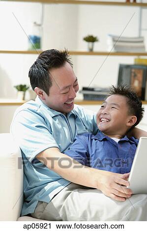 Father and son smiling each other View Large Photo Image Stock Image - Father and son smiling each other. Fotosearch