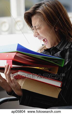 Female executive carrying folders and binders, screaming View Large Photo Image Picture - Female executive carrying folders and binders, screaming. Fotosearch