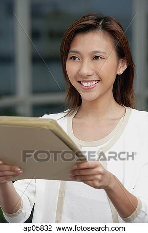 Female executive holding folders, looking away View Large Photo Image Stock Image - Female executive holding folders, looking away. Fotosearch