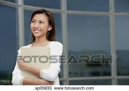 Female executive hugging folders, smiling, looking away View Large Photo Image Stock Image - Female executive hugging folders, smiling, looking away. Fotosearch