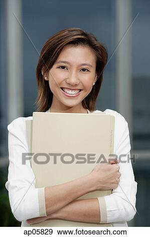 Female executive hugging folders, smiling at camera View Large Photo Image Stock Photo - Female executive hugging folders, smiling at camera. Fotosearch