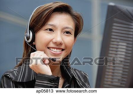 Female executive with hands free device View Large Photo Image Stock Image - Female executive with hands free device. Fotosearch