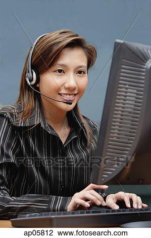Female executive with hands free device, using computer View Large Photo Image Stock Image - Female executive with hands free device, using computer. Fotosearch