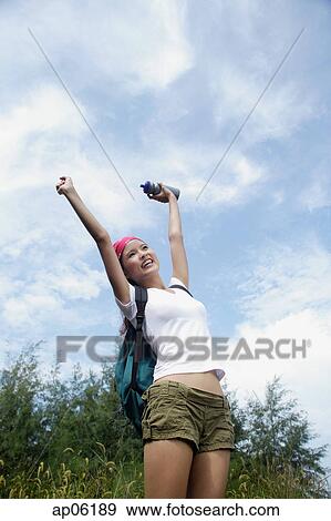 Stock Photo - Female hiker, stretching, low angle view. Fotosearch