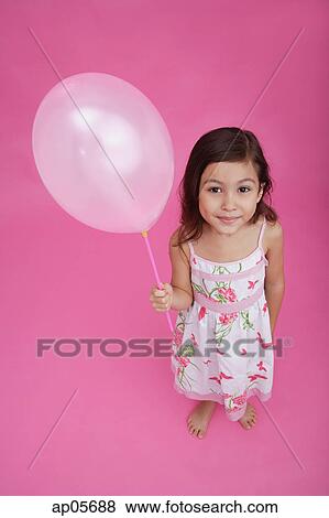 Girl holding balloon, looking up at camera View Large Photo Image Stock Photo - Girl holding balloon, looking up at camera. Fotosearch