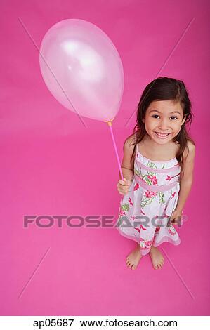 Girl holding balloon, smiling at camera View Large Photo Image Stock Photo - Girl holding balloon, smiling at camera. Fotosearch