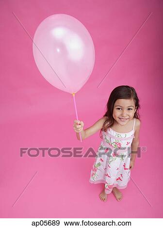Girl with balloon, smiling at camera View Large Photo Image Stock Photo - Girl with balloon, smiling at camera. Fotosearch