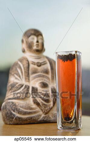 Glass with Tea next to Buddha icon, selective focus View Large Photo Image Stock Photography - Glass with Tea next to Buddha icon, selective focus. Fotosearch
