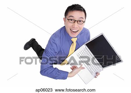Stock Image - High angle view of businessman pointing at laptop. Fotosearch