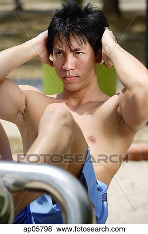 Man doing sit-ups outdoors View Large Photo Image Stock Photo - Man doing sit-ups outdoors. Fotosearch