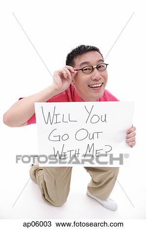 Stock Image - Man holding a sign, asking for a date. Fotosearch