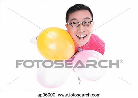 Man holding balloons, looking up at camera View Large Photo Image Stock Image - Man holding balloons, looking up at camera. Fotosearch