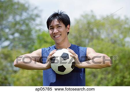 Man holding soccer ball in both hands View Large Photo Image Stock Photography - Man holding soccer ball in both hands. Fotosearch