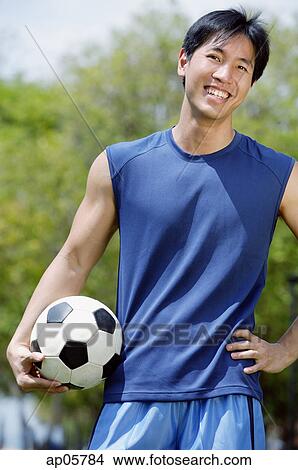 Man holding soccer ball, looking at camera View Large Photo Image Picture - Man holding soccer ball, looking at camera. Fotosearch