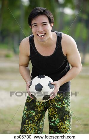 Man holding soccer ball, smiling at camera View Large Photo Image Stock Image - Man holding soccer ball, smiling at camera. Fotosearch