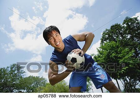 Man holding soccer ball, smiling at camera View Large Photo Image Stock Photo - Man holding soccer ball, smiling at camera. Fotosearch