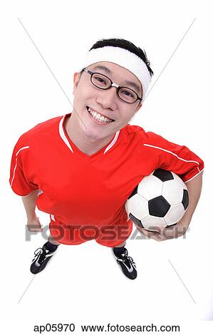 Man holding soccer ball under arm, looking at camera View Large Photo Image Stock Image - Man holding soccer ball under arm, looking at camera. Fotosearch