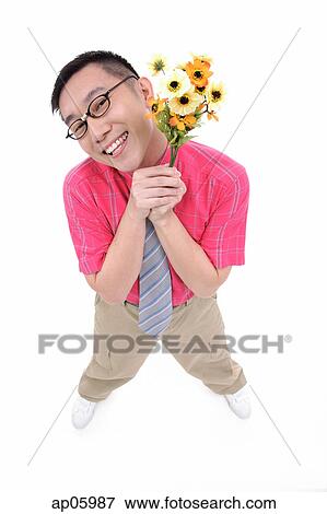 Stock Photo - Man in shirt and tie holding flower bouquet, smiling at camera. Fotosearch