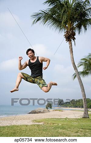 Man jumping in air, looking at camera View Large Photo Image Picture - Man jumping in air, looking at camera. Fotosearch