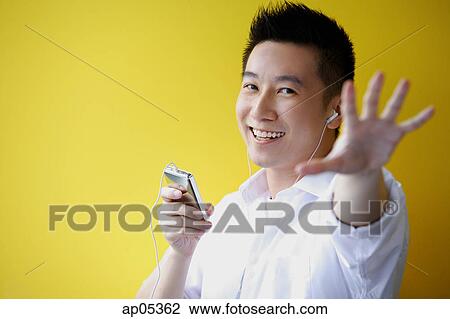 Man listening to MP3 Player, hand reaching towards camera View Large Photo Image Stock Image - Man listening to MP3 Player, hand reaching towards camera. Fotosearch