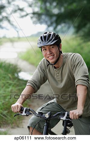 Stock Image - Man on a bicycle, smiling at camera. Fotosearch