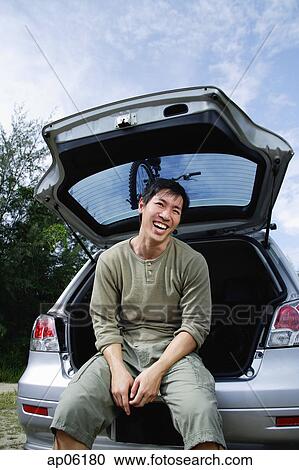 Man sitting in boot of car View Large Photo Image Stock Image - Man sitting in boot of car. Fotosearch
