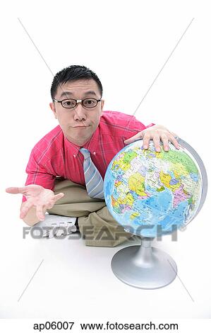 Man sitting on floor, hand on globe, shrugging View Large Photo Image Stock Photo - Man sitting on floor, hand on globe, shrugging. Fotosearch