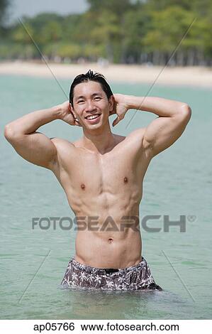 Man standing in sea, hands on head View Large Photo Image Stock Photograph - Man standing in sea, hands on head. Fotosearch