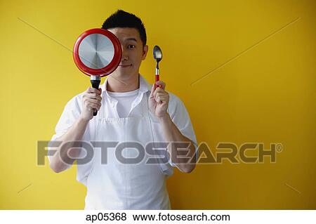 Man wearing apron, holding saucepan and spoon View Large Photo Image Stock Photo - Man wearing apron, holding saucepan and spoon. Fotosearch