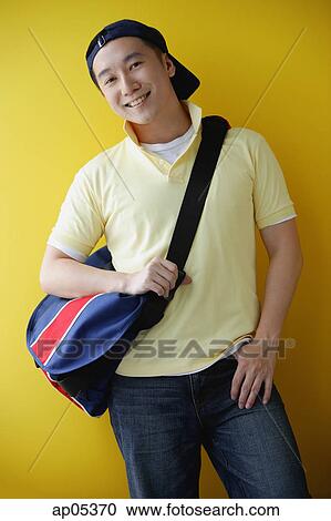 Stock Image - Man wearing cap and carrying satchel. Fotosearch