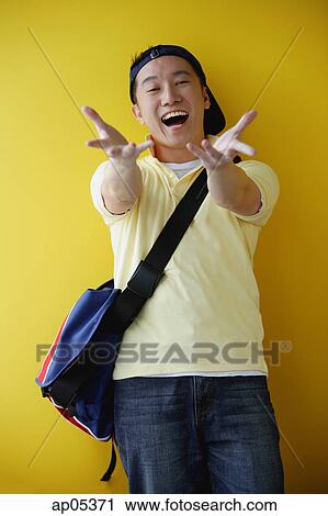 Man wearing cap and carrying satchel, reaching towards camera, smiling View Large Photo Image Stock Image - Man wearing cap and carrying satchel, reaching towards camera, smiling. Fotosearch