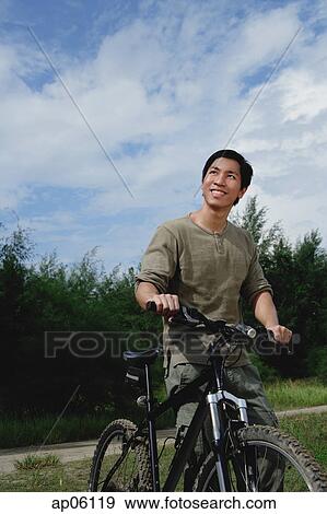 Man with bicycle, outdoors, smiling View Large Photo Image Stock Photo - Man with bicycle, outdoors, smiling. Fotosearch