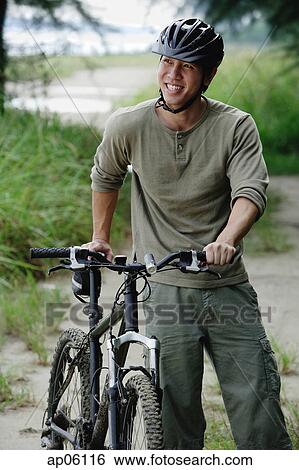 Stock Photograph - Man with bicycle, outdoors. Fotosearch