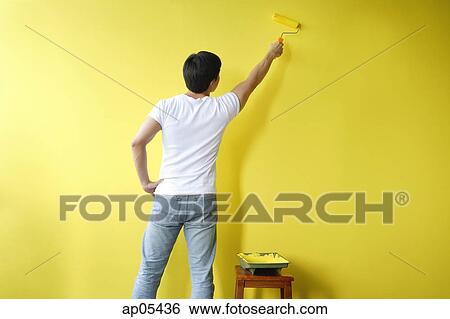 Man with paint roller, painting wall yellow View Large Photo Image Stock Photograph - Man with paint roller, painting wall yellow. Fotosearch