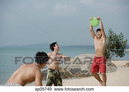 Men on beach playing with Frisbee View Large Photo Image Stock Photo - Men on beach playing with Frisbee. Fotosearch