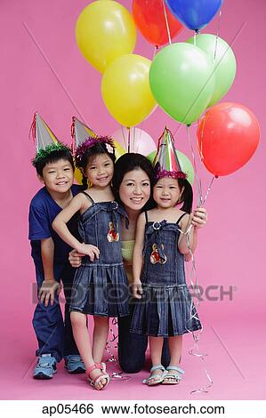 Stock Photograph - Mother and three children, posing with balloons. Fotosearch