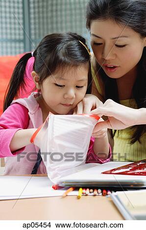 Mother with young daughter, looking at bag View Large Photo Image Picture - Mother with young daughter, looking at bag. Fotosearch