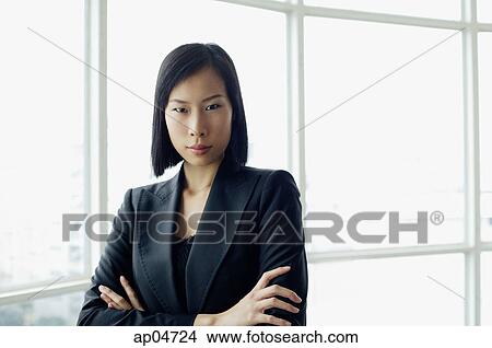 Picture - Portrait of businesswoman, arms crossed, looking at camera. Fotosearch