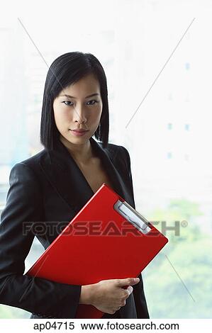 Stock Photography - Portrait of businesswoman, holding clipboard file. Fotosearch