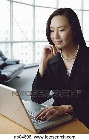 Portrait of businesswoman using laptop, hand on chin View Large Photo Image Stock Photograph - Portrait of businesswoman using laptop, hand on chin. Fotosearch