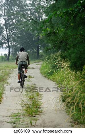 Stock Photo - Rear view of a man cycling. Fotosearch