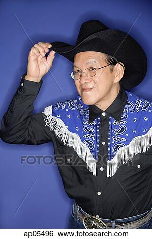 Senior man dressed in cowboy attire, adjusting hat View Large Photo Image Stock Photograph - Senior man dressed in cowboy attire, adjusting hat. Fotosearch