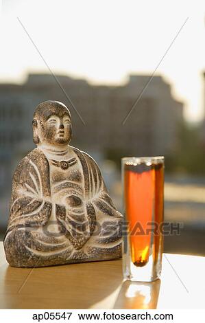 Still life with glass of tea and Buddha icon View Large Photo Image Stock Photo - Still life with glass of tea and Buddha icon. Fotosearch