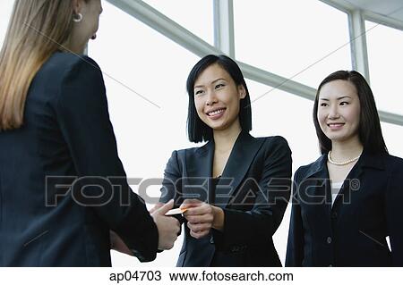 Three businesswomen exchanging business cards View Large Photo Image Stock Image - Three businesswomen exchanging business cards. Fotosearch
