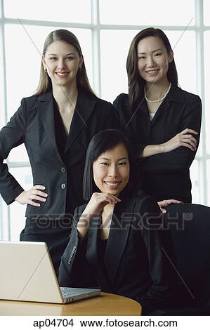 Three businesswomen, smiling at camera, portrait View Large Photo Image Picture - Three businesswomen, smiling at camera, portrait. Fotosearch