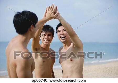 Three men on beach, putting hands together View Large Photo Image Stock Image - Three men on beach, putting hands together. Fotosearch
