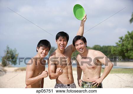 Three men on beach, smiling at camera View Large Photo Image Stock Image - Three men on beach, smiling at camera. Fotosearch