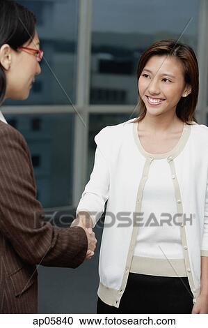 Two businesswomen shaking hands View Large Photo Image Stock Image - Two businesswomen shaking hands. Fotosearch