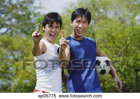 Two men looking at camera, making hand sign View Large Photo Image Stock Photography - Two men looking at camera, making hand sign. Fotosearch