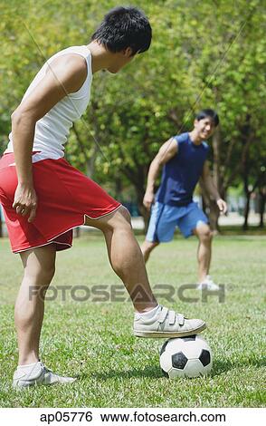 Two men playing soccer in park View Large Photo Image Stock Photograph - Two men playing soccer in park. Fotosearch